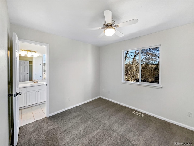 unfurnished room featuring ceiling fan, light colored carpet, and sink