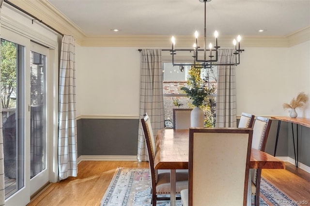 dining space featuring a chandelier, crown molding, and light hardwood / wood-style floors