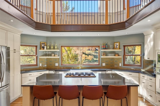 kitchen with a center island, light hardwood / wood-style flooring, stainless steel appliances, and a healthy amount of sunlight