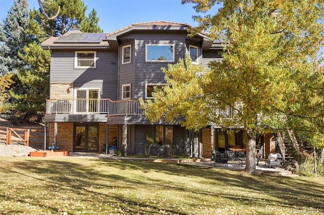 back of house featuring a yard, a patio area, and a wooden deck