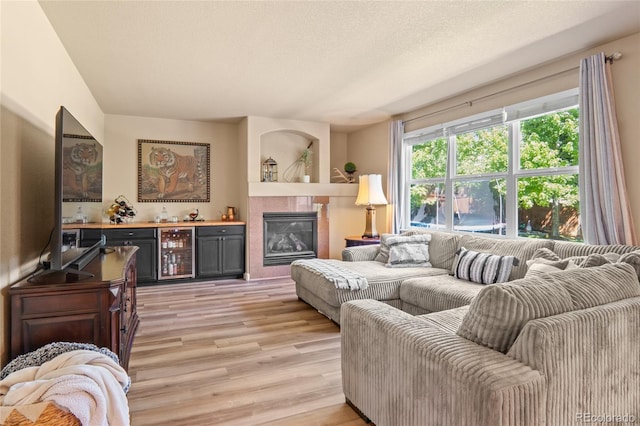 2192 Paint Pony Cir, Castle Rock, CO 80108 - living area featuring light wood-style floors, a bar, and a tile fireplace