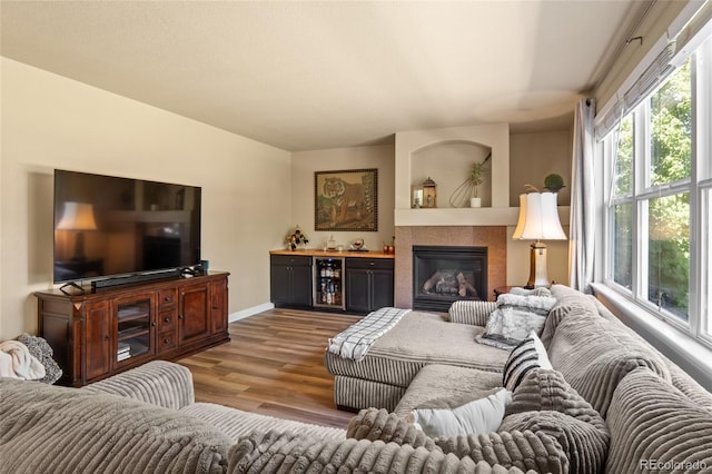 2192 Paint Pony Cir, Castle Rock, CO 80108 - living area featuring healthy amount of natural light, wood finished floors, beverage cooler, and a glass covered fireplace