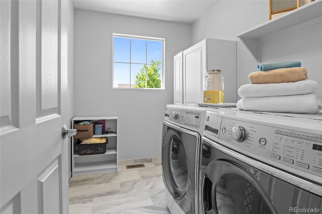 2192 Paint Pony Cir, Castle Rock, CO 80108 - laundry room with cabinet space, washer and clothes dryer, and light marble finish flooring