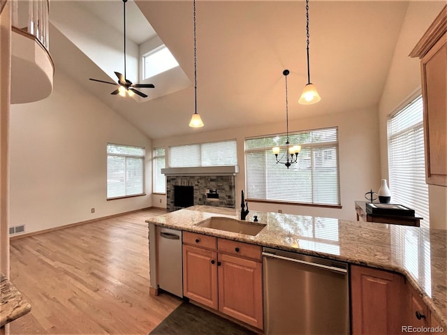 kitchen with dishwasher, open floor plan, a sink, and light wood-style floors