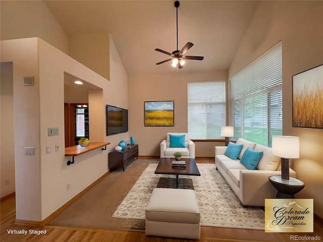 living area with high vaulted ceiling, baseboards, and a ceiling fan