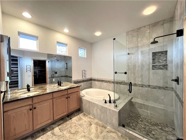 full bathroom featuring double vanity, a stall shower, a sink, and a bath