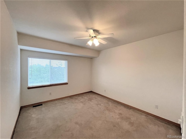 unfurnished room with light carpet, a ceiling fan, visible vents, and baseboards