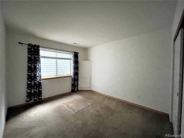 carpeted empty room with baseboards