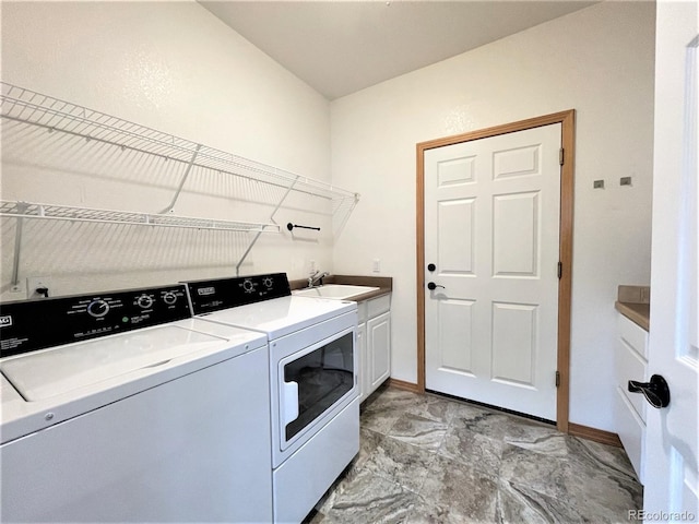 laundry room featuring cabinet space, baseboards, marble finish floor, washing machine and dryer, and a sink