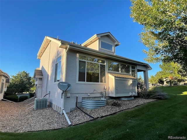 view of side of home with a yard and central AC unit