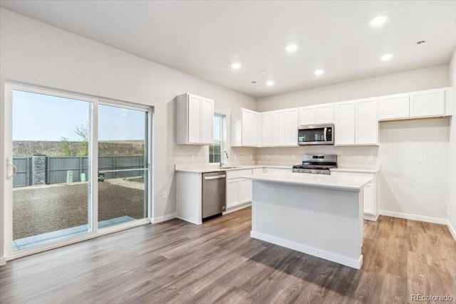 19018 E 94th Pl, Commerce City, CO 80022 - kitchen with stainless steel appliances, light countertops, light wood-type flooring, white cabinets, and recessed lighting