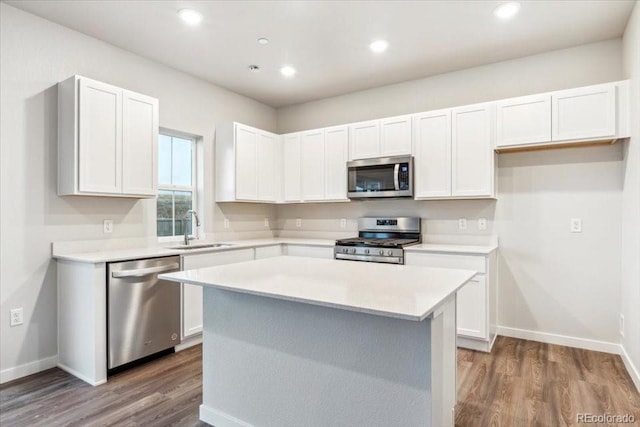 19018 E 94th Pl, Commerce City, CO 80022 - kitchen with stainless steel appliances, a sink, wood finished floors, light countertops, and white cabinets