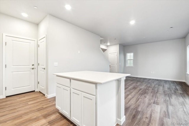 19018 E 94th Pl, Commerce City, CO 80022 - kitchen with light wood finished floors, white cabinets, light countertops, baseboards, and recessed lighting