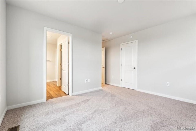 19018 E 94th Pl, Commerce City, CO 80022 - unfurnished bedroom featuring carpet, baseboards, and ensuite bath