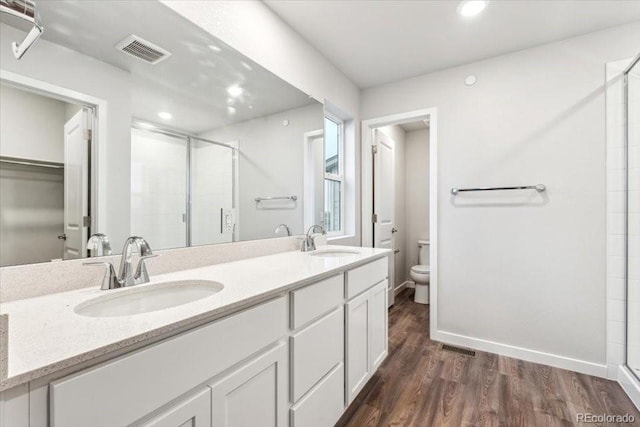19018 E 94th Pl, Commerce City, CO 80022 - bathroom featuring a stall shower, toilet, wood finished floors, double vanity, and recessed lighting