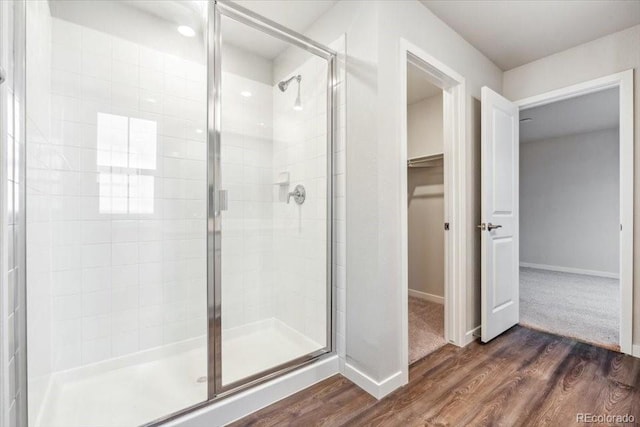 19018 E 94th Pl, Commerce City, CO 80022 - full bath featuring a shower stall, a walk in closet, wood finished floors, and baseboards