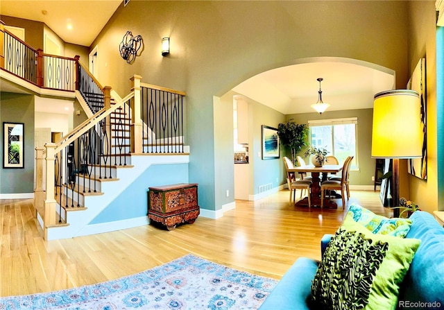 6002 Alkire Ct, Arvada, CO 80004 - living room with arched walkways, wood finished floors, baseboards, stairs, and recessed lighting
