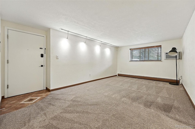 1045 N Clarkson St Unit 102, Denver, CO 80218 - spare room featuring carpet floors, a wall mounted air conditioner, and a textured ceiling