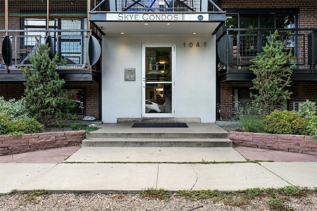 1045 N Clarkson St Unit 102, Denver, CO 80218 - property entrance featuring stucco siding, brick siding, and a balcony