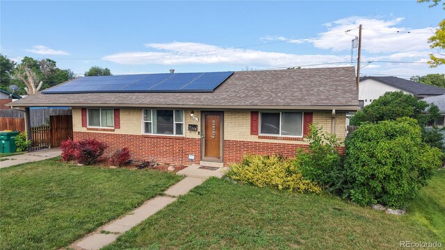 41 S Fenton St, Lakewood, CO 80226 - view of front facade featuring brick siding, roof with shingles, roof mounted solar panels, and driveway