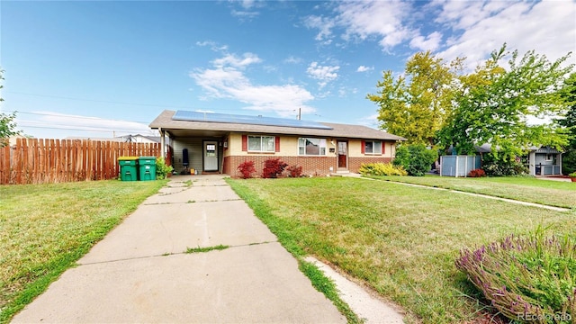 41 S Fenton St, Lakewood, CO 80226 - view of front facade featuring driveway, solar panels, brick siding, and an attached carport