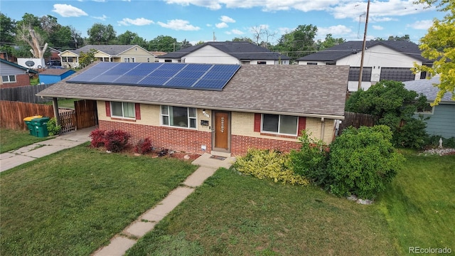 41 S Fenton St, Lakewood, CO 80226 - view of front of property with brick siding, a shingled roof, concrete driveway, solar panels, and a residential view