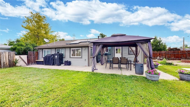 41 S Fenton St, Lakewood, CO 80226 - back of property featuring a patio area, roof mounted solar panels, a gazebo, and a fenced backyard