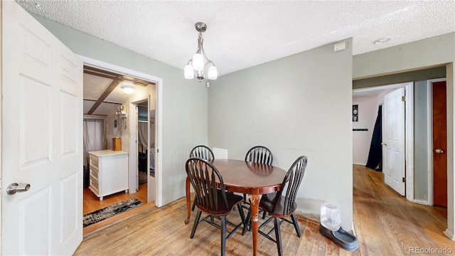 41 S Fenton St, Lakewood, CO 80226 - dining area featuring light wood-style floors, a chandelier, and a textured ceiling