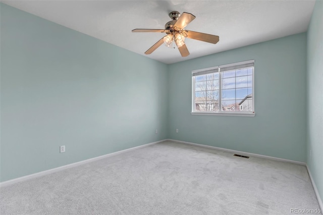 carpeted empty room featuring visible vents, baseboards, and ceiling fan