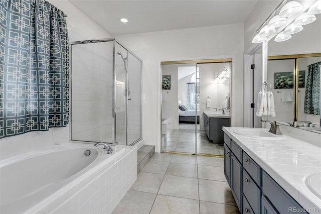 bathroom with a sink, a shower stall, a bath, and ensuite bathroom