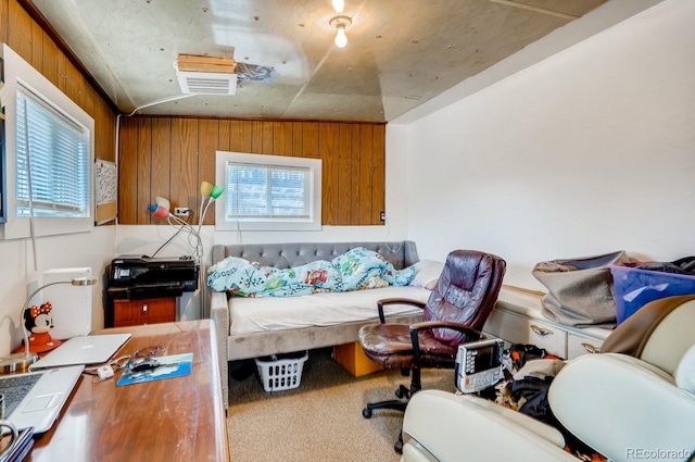 bedroom with wood walls, multiple windows, and carpet