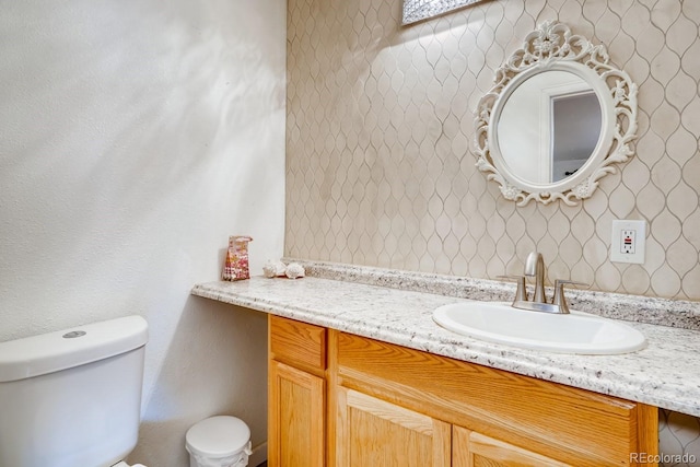 half bathroom with vanity and toilet