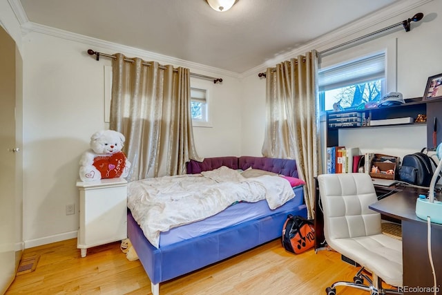 bedroom with baseboards, ornamental molding, and wood finished floors