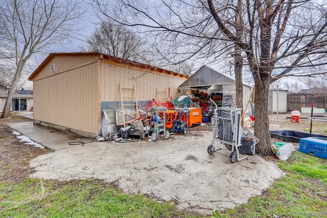 view of outdoor structure with fence and an outbuilding