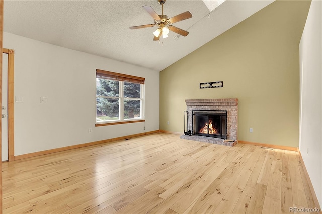 8376 Cobblestone St, Highlands Ranch, CO 80126 - unfurnished living room featuring a brick fireplace, a ceiling fan, wood finished floors, high vaulted ceiling, and a textured ceiling