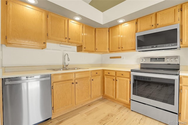 8376 Cobblestone St, Highlands Ranch, CO 80126 - kitchen featuring stainless steel appliances, light wood-type flooring, light countertops, light brown cabinetry, and recessed lighting