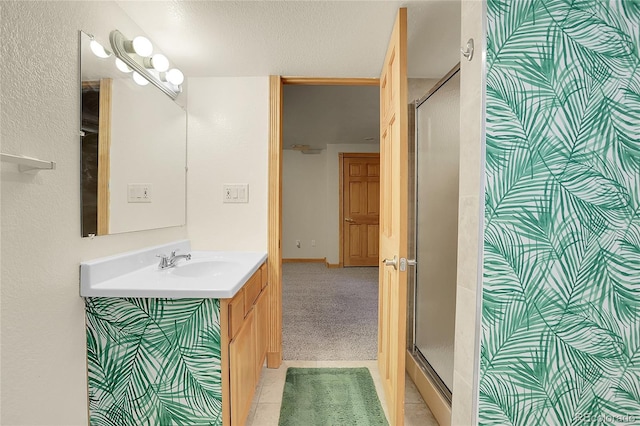 8376 Cobblestone St, Highlands Ranch, CO 80126 - bathroom with vanity, a stall shower, a textured ceiling, and tile patterned floors