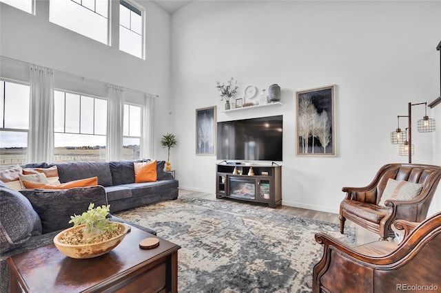 living room with a towering ceiling and hardwood / wood-style flooring