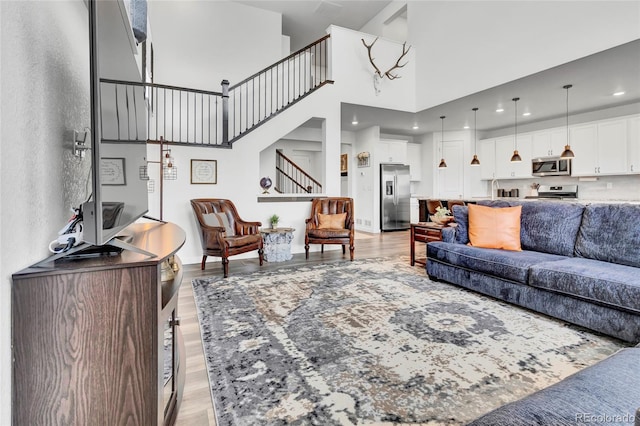 living room with a towering ceiling and light hardwood / wood-style floors