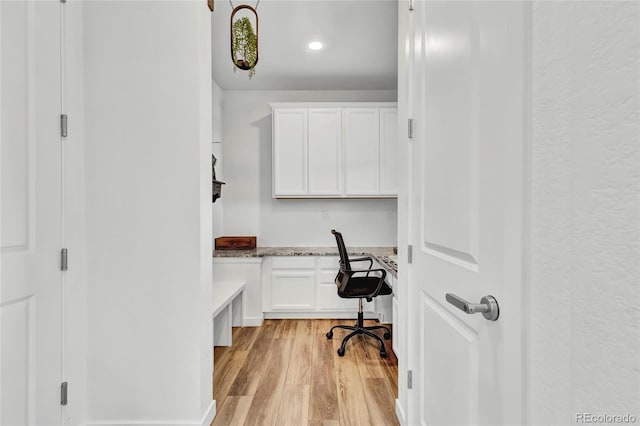 office space featuring light wood-type flooring and built in desk