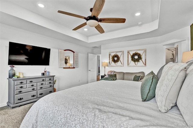 bedroom featuring carpet, a tray ceiling, and ceiling fan