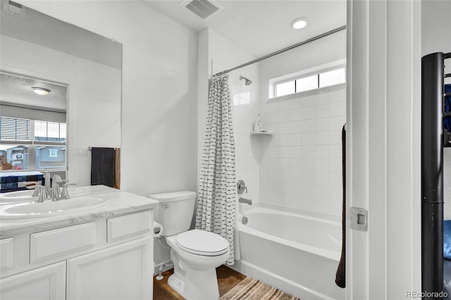 full bathroom featuring hardwood / wood-style floors, vanity, toilet, and shower / bathtub combination with curtain