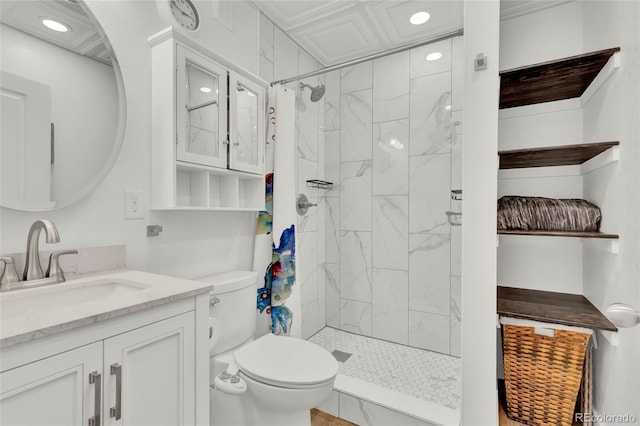 bathroom featuring vanity, toilet, and tiled shower