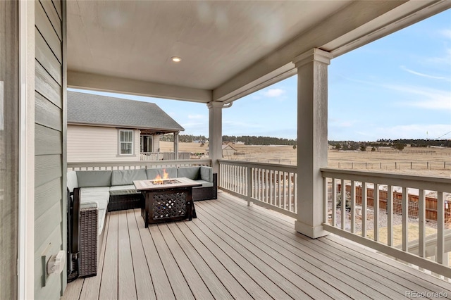 wooden deck with a fire pit and a rural view