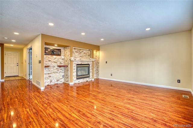 unfurnished living room with hardwood / wood-style flooring and a textured ceiling