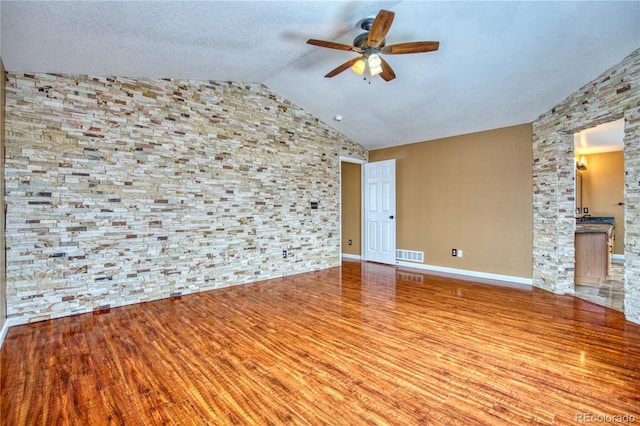 spare room featuring ceiling fan, lofted ceiling, and light wood-type flooring