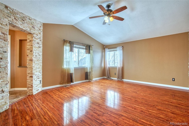 spare room featuring hardwood / wood-style floors, a textured ceiling, vaulted ceiling, and ceiling fan