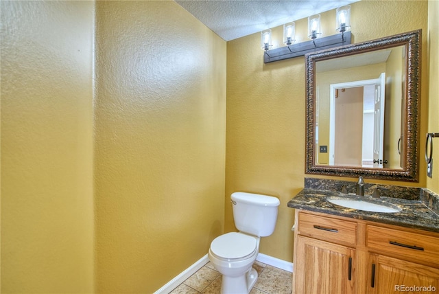 bathroom featuring tile patterned floors, vanity, a textured ceiling, and toilet