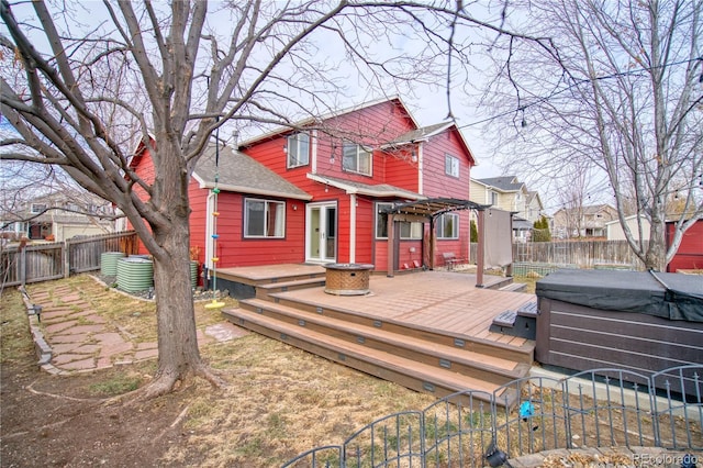 rear view of house with a hot tub, a gate, a pergola, a fenced backyard, and a wooden deck