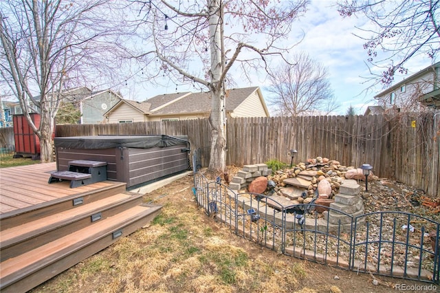 view of yard with a deck, a fenced backyard, and a hot tub